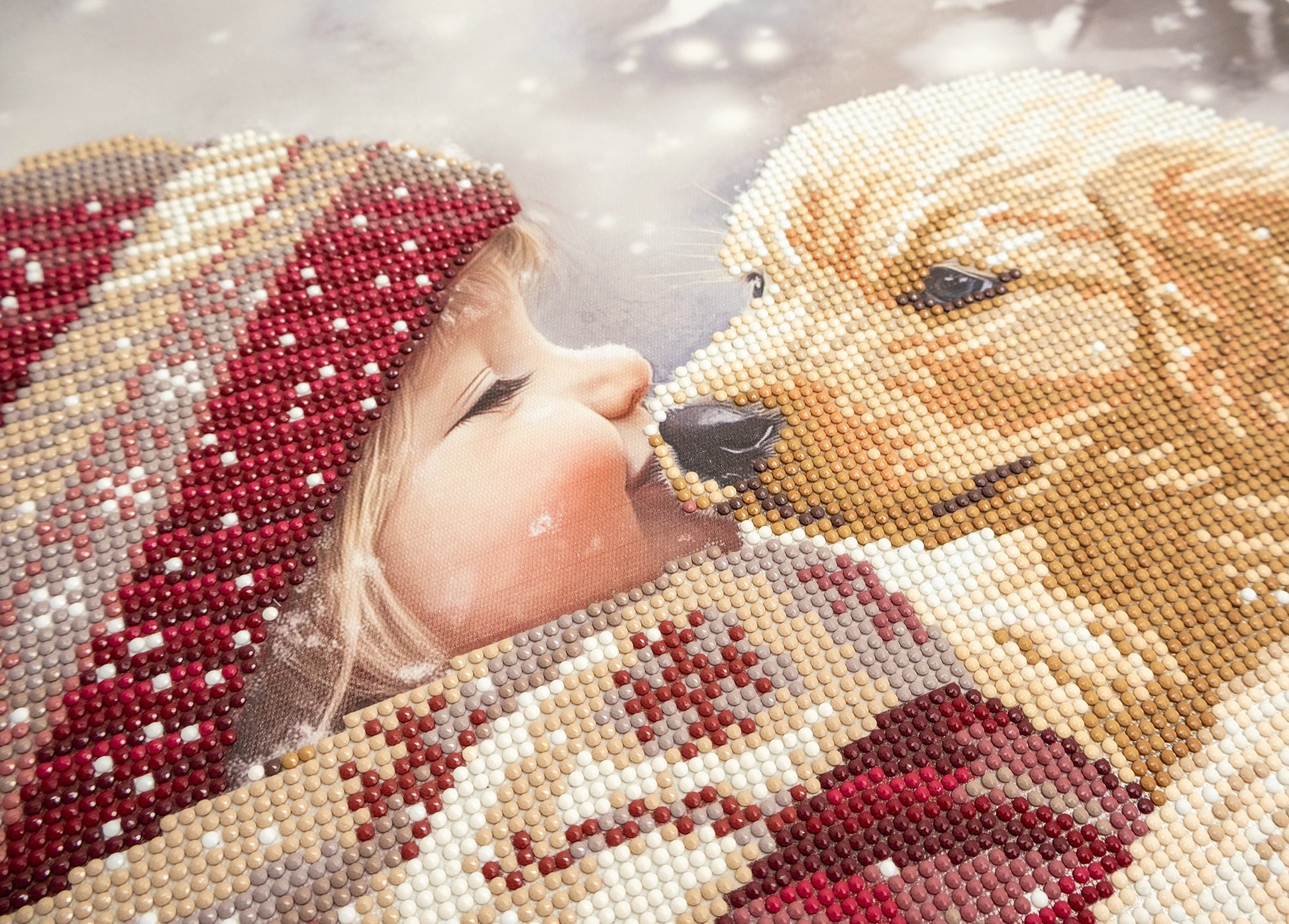 Child wearing a beaded hat kissing a beaded bear toy