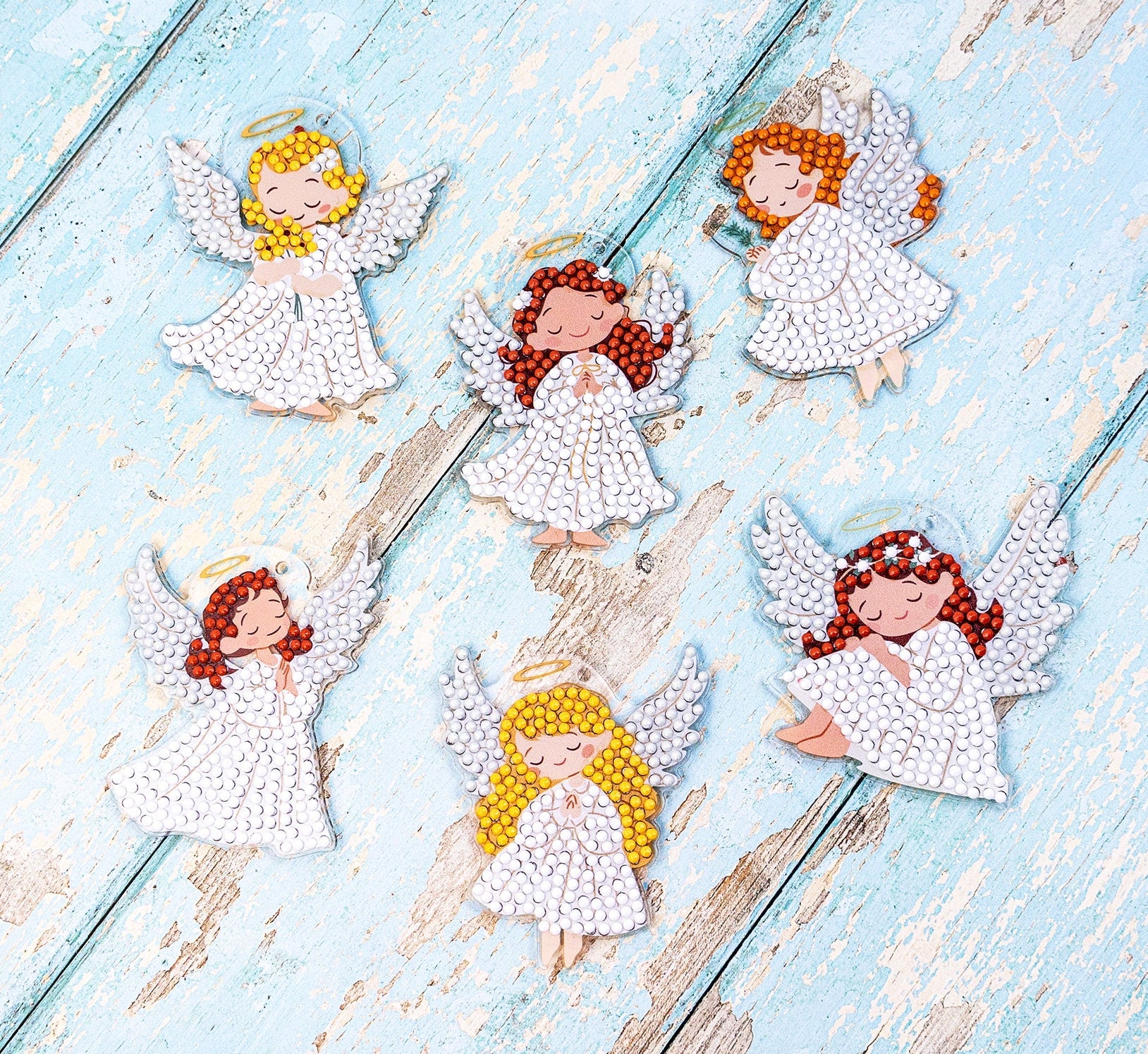 Dazzle Dots Diamond Art kit Decorative angel figurines with red hair on a light blue wooden surface
