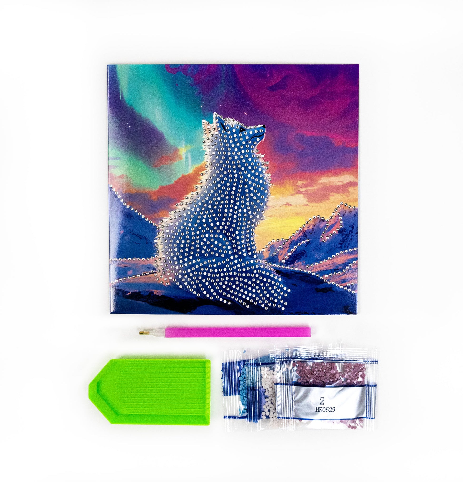 Card with a fox design on a colorful sky cover, pen, and pencil sharpener on a white background