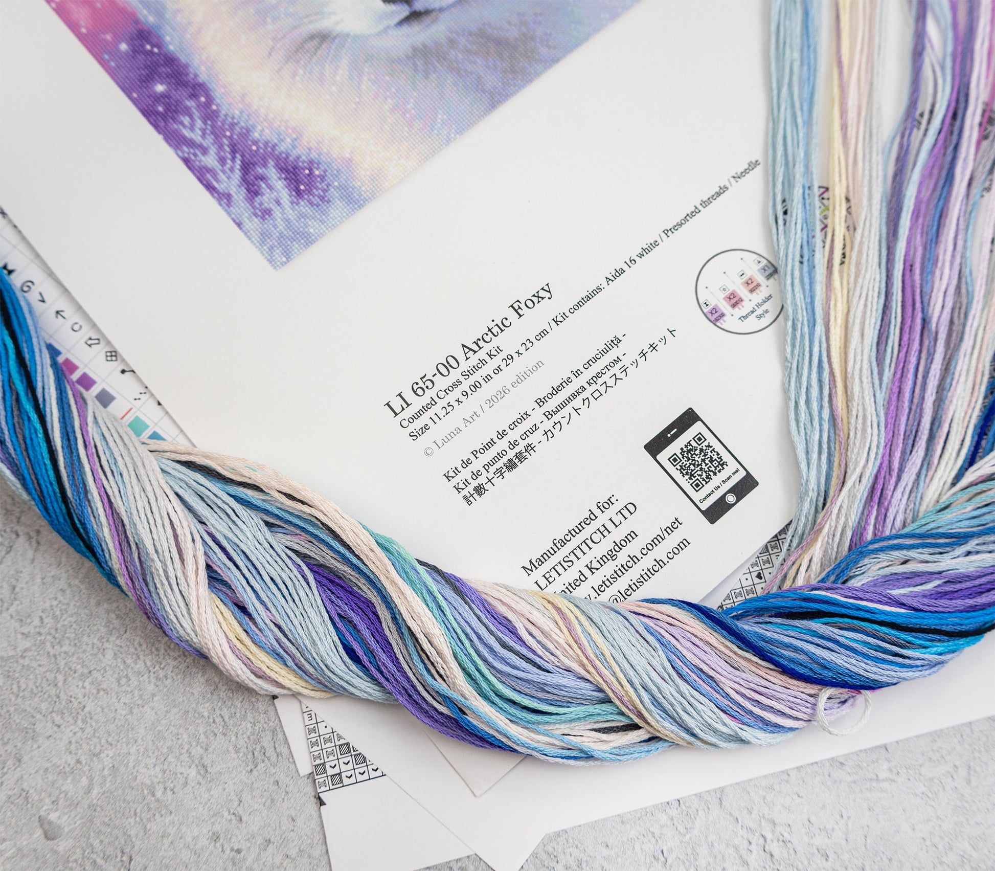Colorful yarn skein on a printed material with text and a QR code.