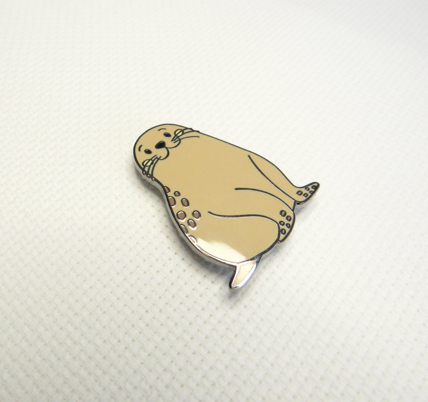 Beige seal-shaped Needleminder on a white background