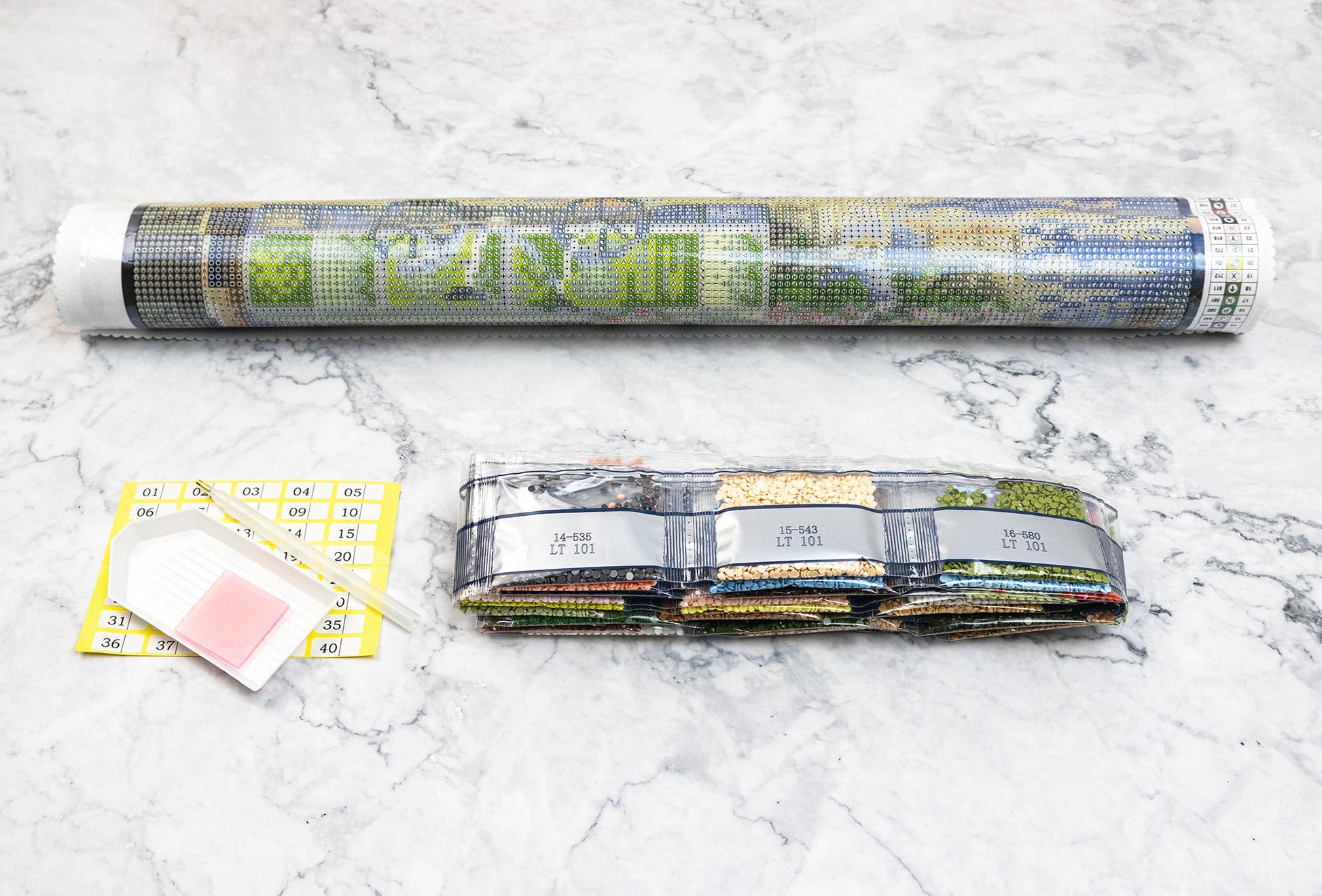 Diamond painting kit Dazzle Dots components on a marble surface