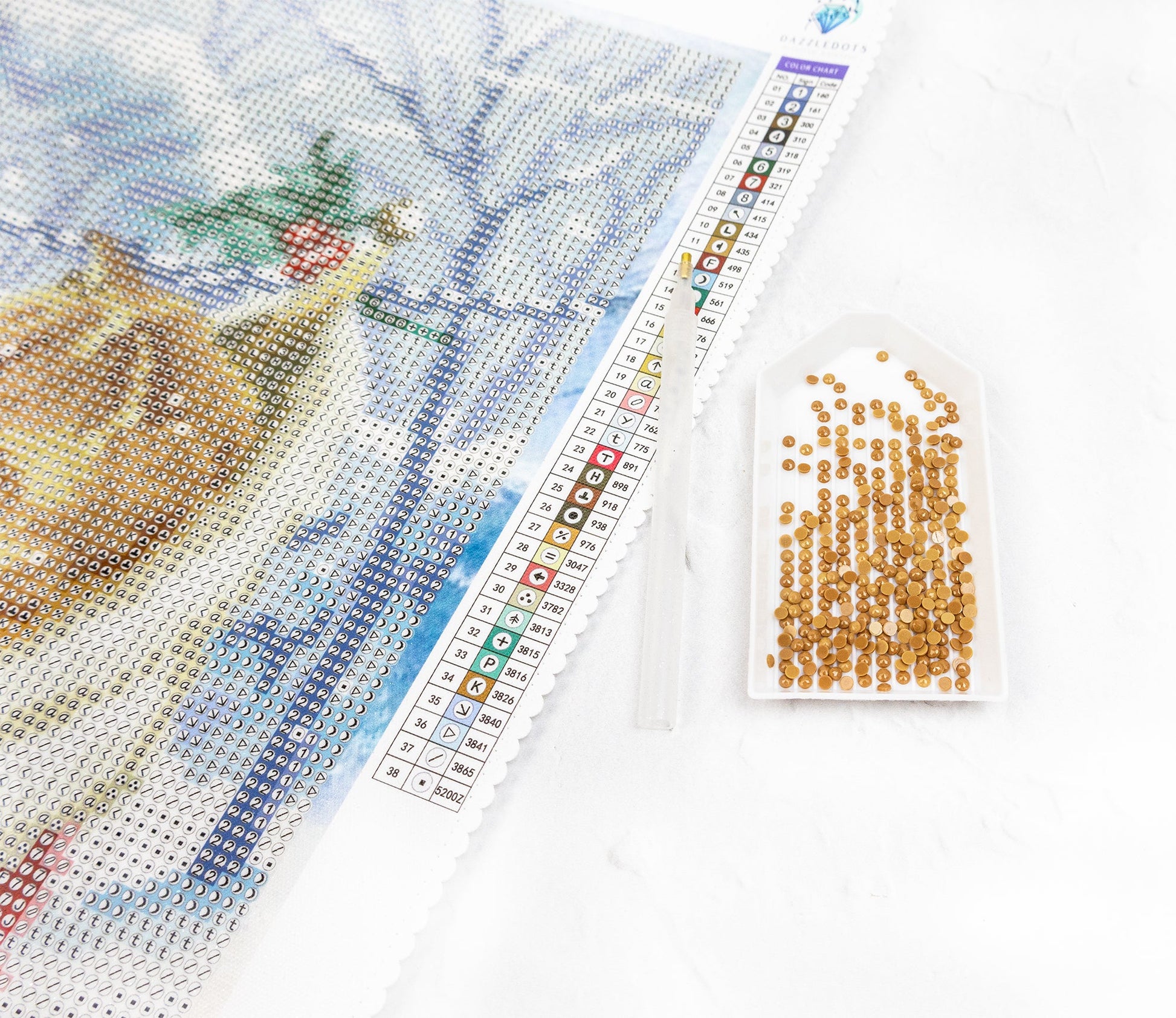 diamond painting project with a completed section and a packet of crystals on a white backgroun