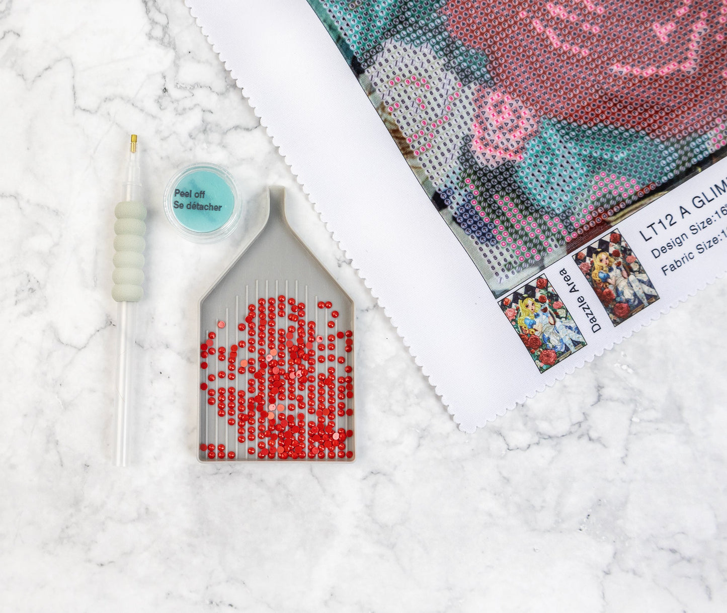 Diamond Art kit with a partially completed red rose design on a textured white surface.