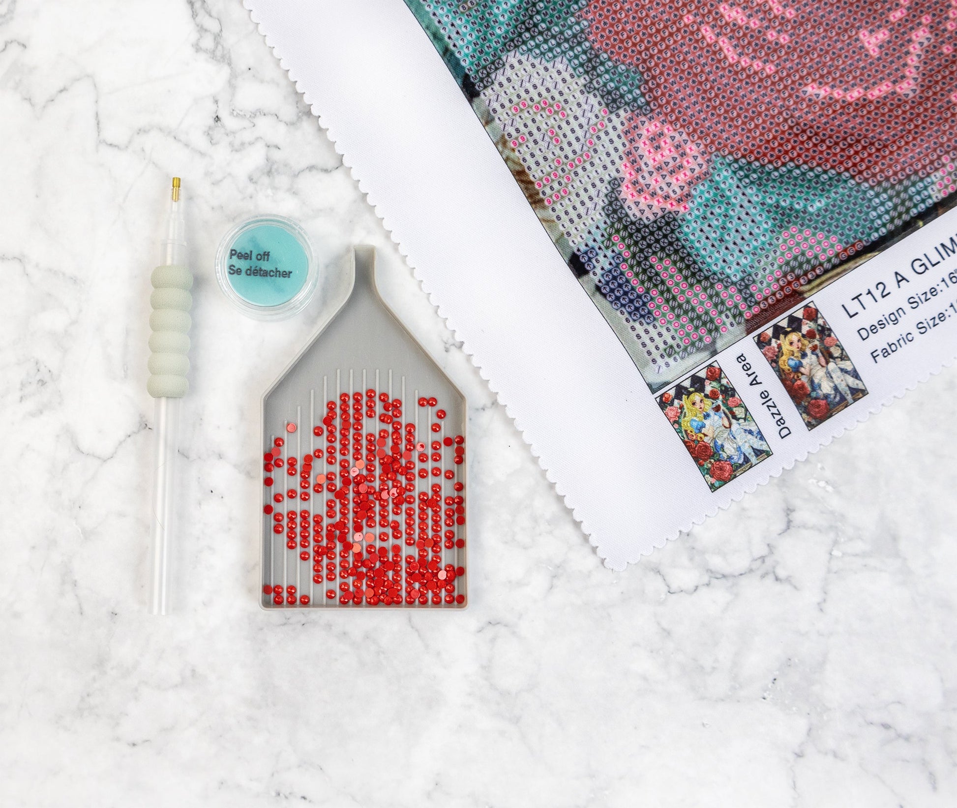 Diamond Art kit with a partially completed red rose design on a textured white surface.